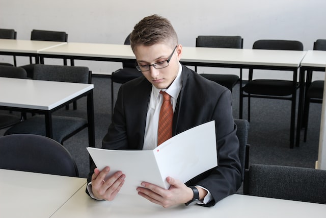young man holding a folder in an empty room